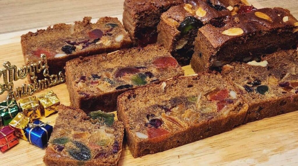 A photo of English fruit cake slices on a wooden plate.
