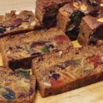 A photo of English fruit cake slices on a wooden plate.