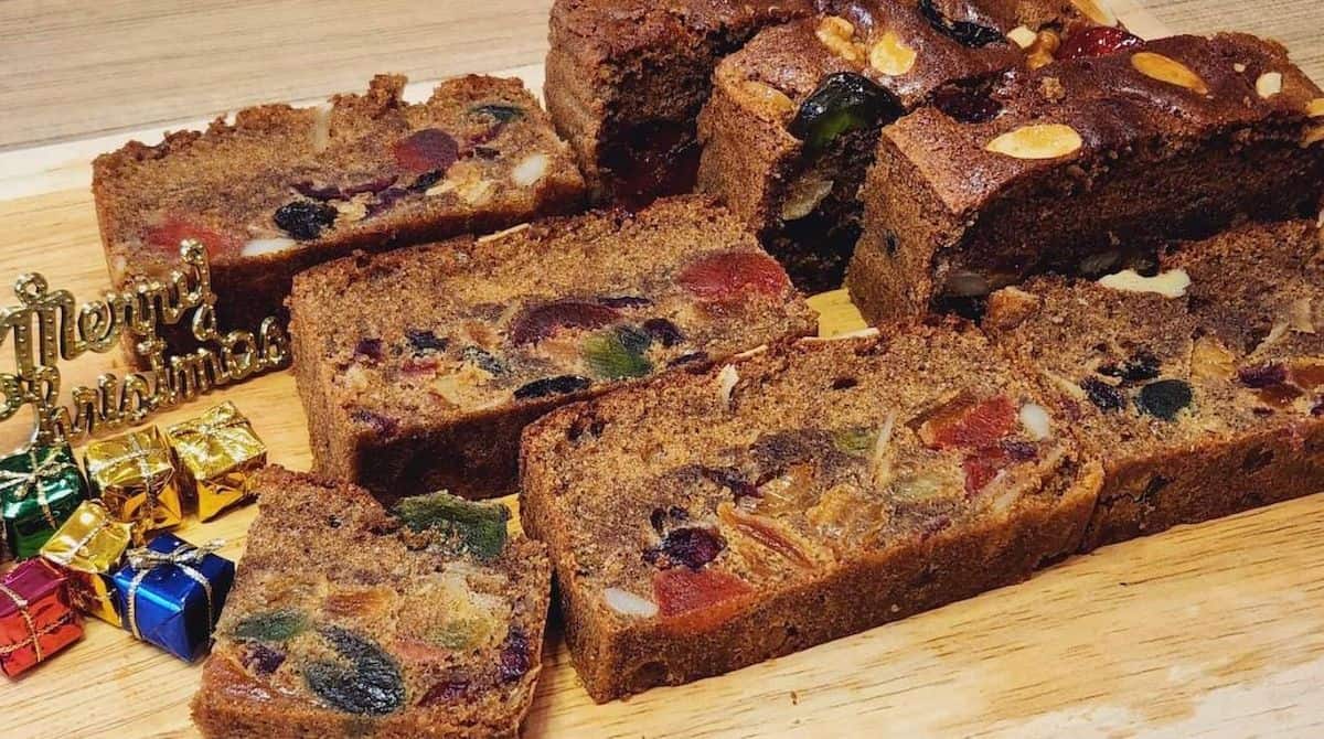 A photo of English fruit cake slices on a wooden plate.