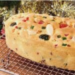 vanilla fruit cake on a cooling rack with christmas decorations.