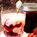 A glass of Korean Strawberry Milk with some fresh strawberries.
