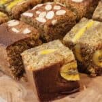 Banana cake cut in squares on a wooden board.
