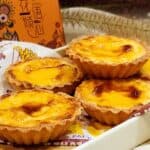 Hokkaido Cheese Tarts on a tray in front of an orange box.