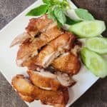 Flourless fried chicken slices on a white plate, garnished with lettuce.