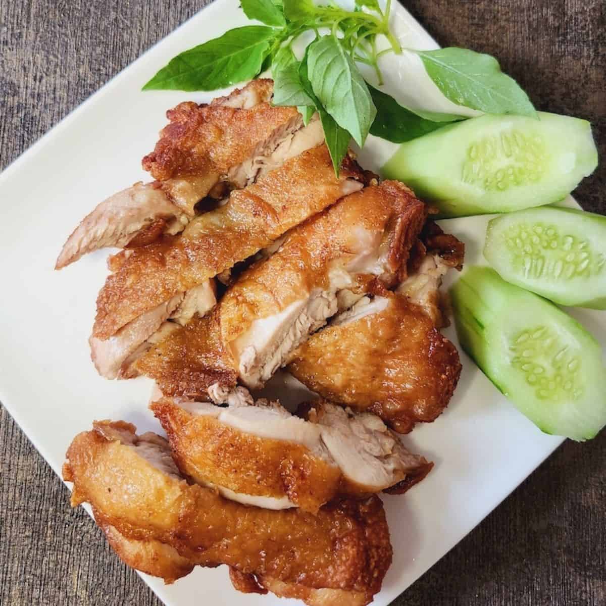 Flourless fried chicken slices on a white plate, garnished with lettuce.