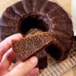 A hand holding a slice of Malaysian honeycomb cake with its beehive-like texture.