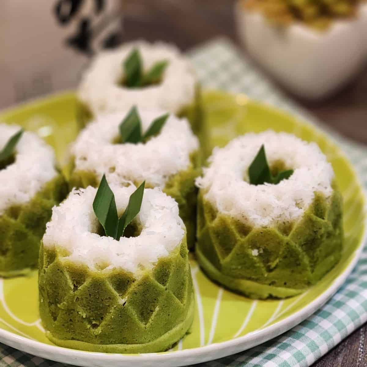 A plate of putu ayu pandan with pandan leaves as decoration.