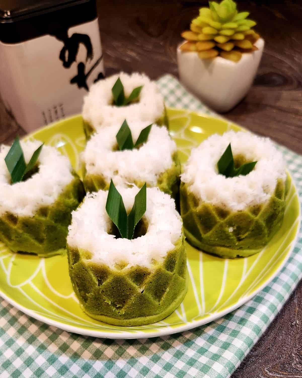 A plate of putu ayu pandan with pandan leaves as decoration.