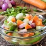 A bowl of acar timun with green chilis and carrots.