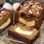 Banana pound cake with cream cheese on a cooling rack.