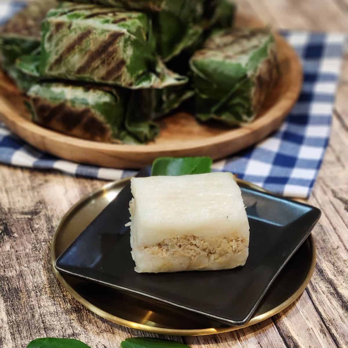 A small black plate with lemper ayam.