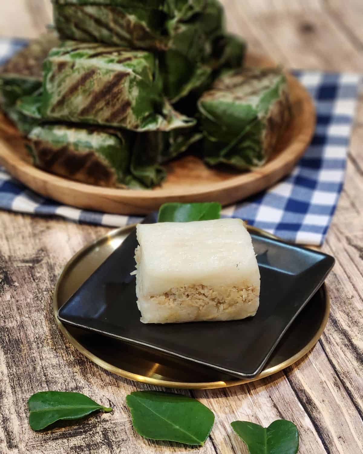 A small black plate with lemper ayam.