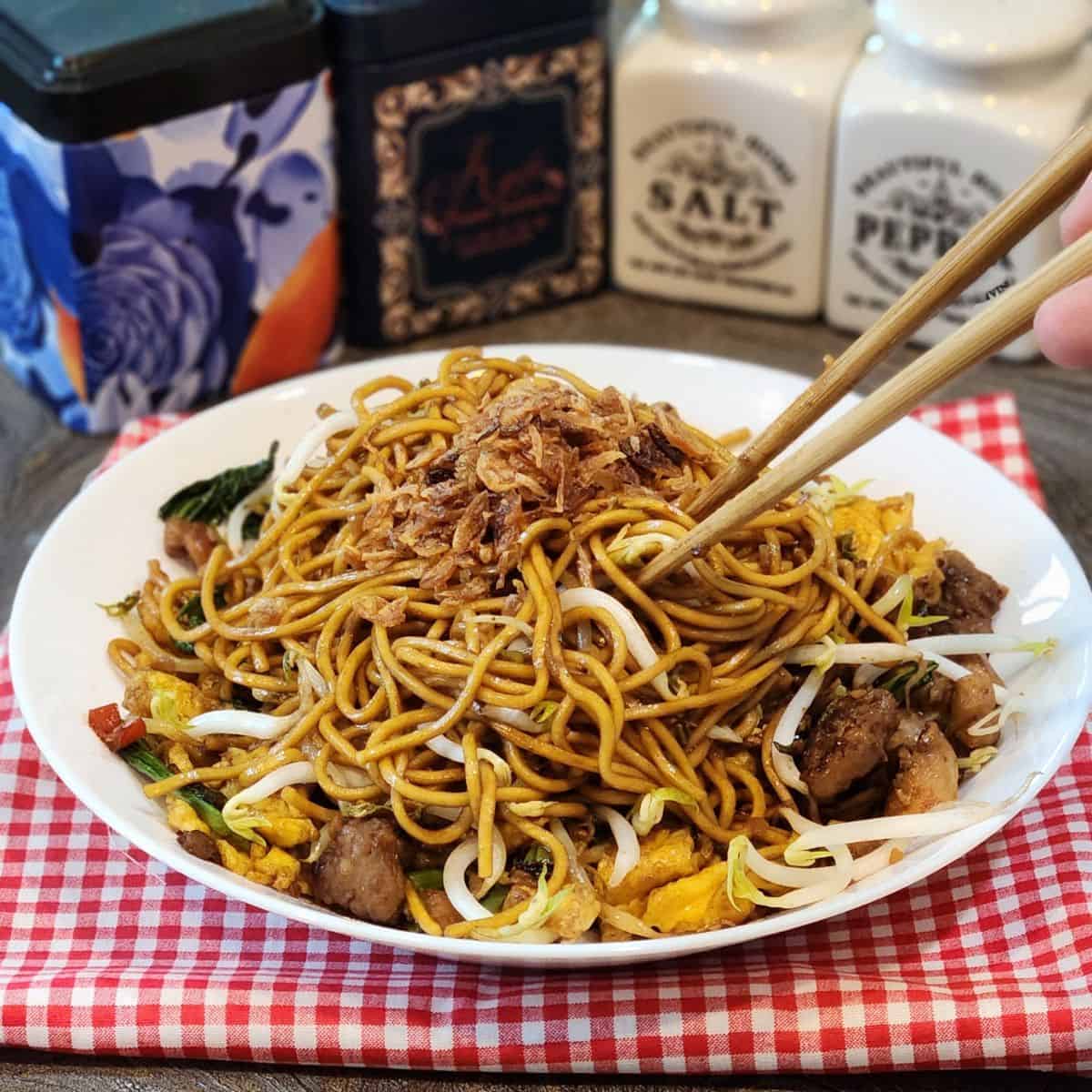A plate of Mie Goreng, Indonesian stir fried noodles with chopsticks.