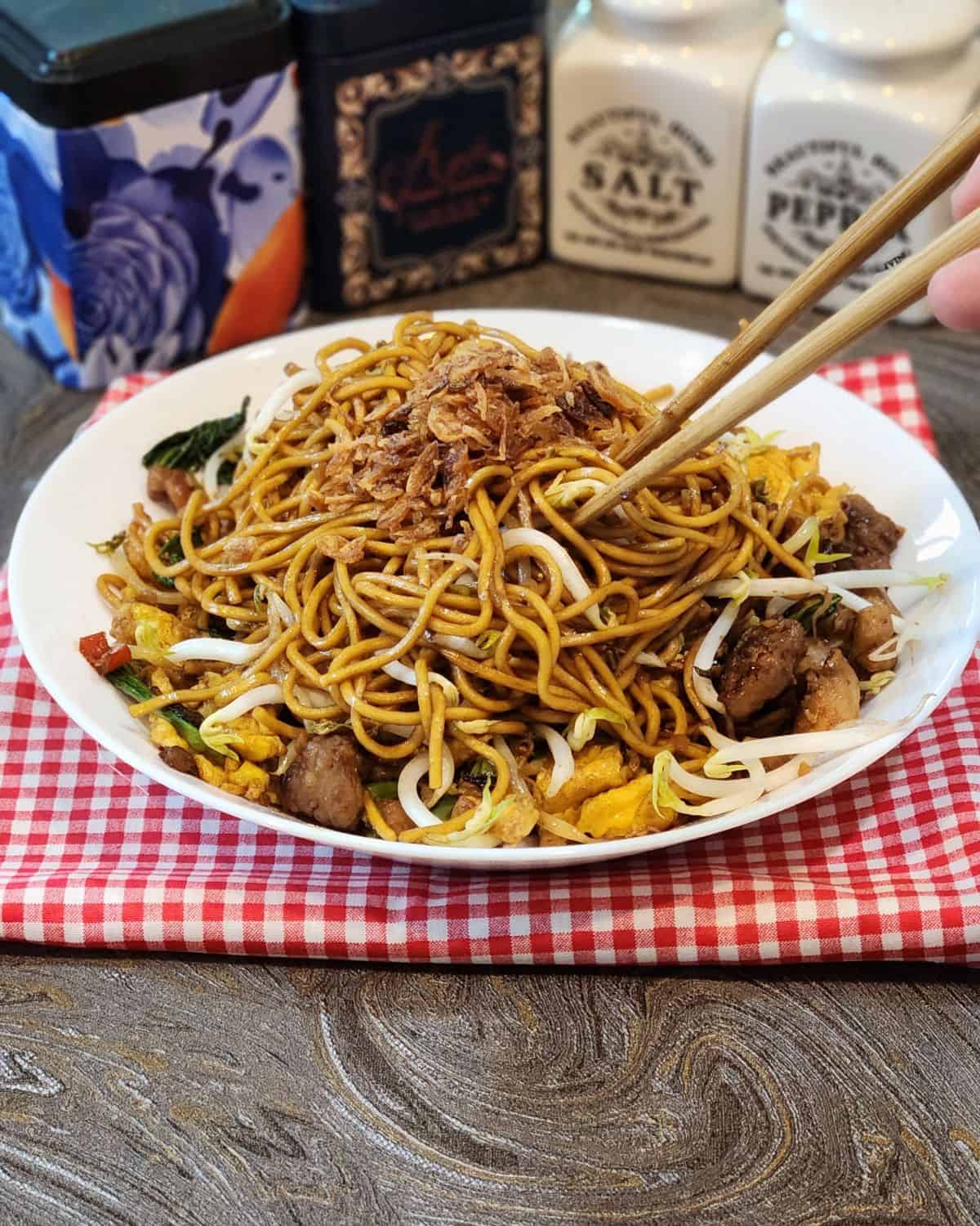 A plate of Mie Goreng, Indonesian stir fried noodles with chopsticks.