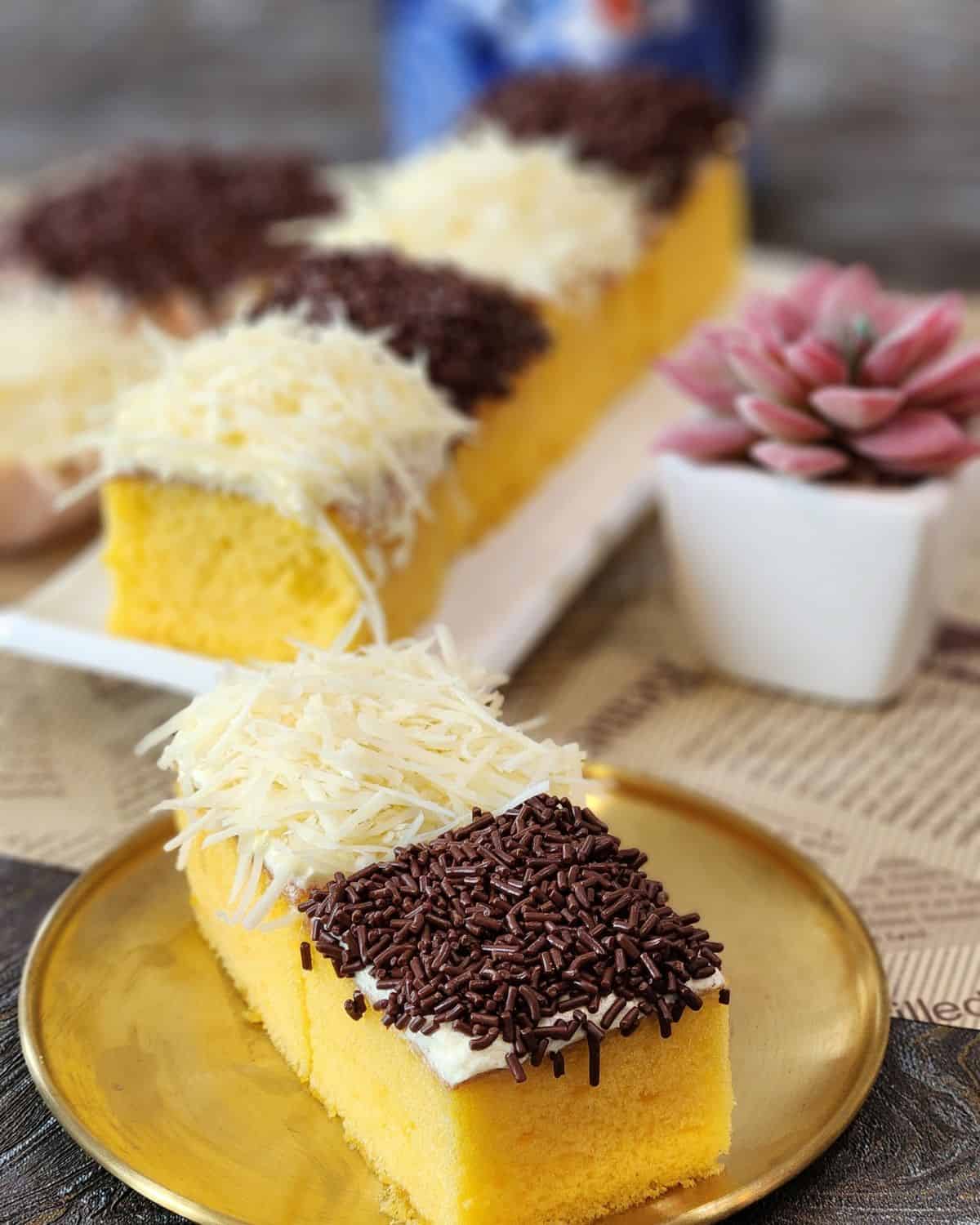 A plate with two mini cakes with cheese and chocolate toppings.