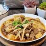 A plate of Szechuan tofu with mushrooms and ground pork.