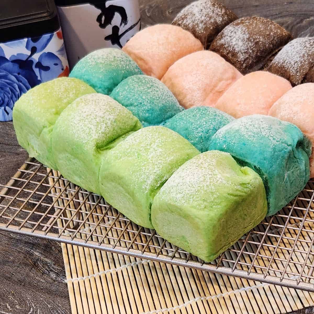 Colorful Japanese Milk Buns on a wire rack.