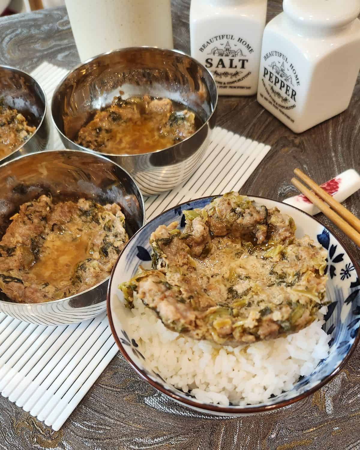 A bowl of rice with steamed ground pork or nyuk piang and a few other bowls.