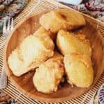 Several pisang goreng on a wooden plate.