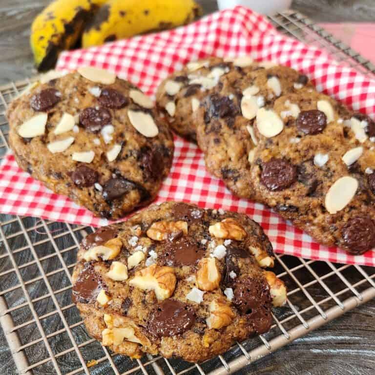 Several banana almond soft cookies on a cooling rack with red white cloth.