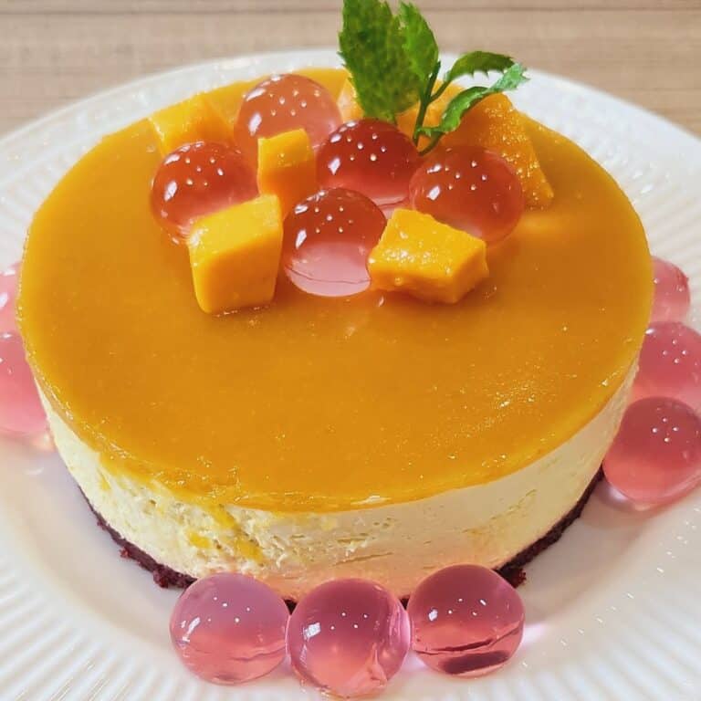 A plate of no bake mango cheesecake with decoration.