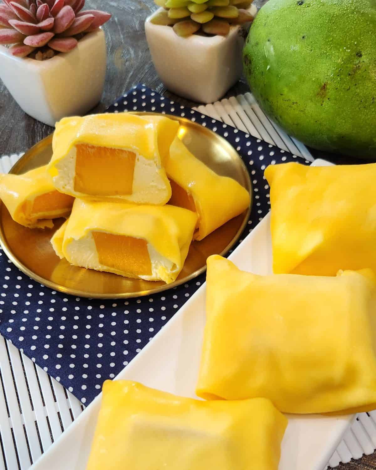 A stack of sliced mango pancakes on a golden plate with several more on the side.