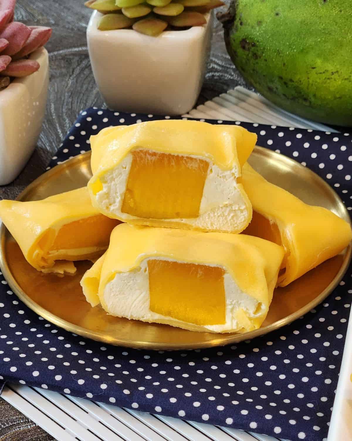 A close up look of sliced mango pancakes on a golden plate.